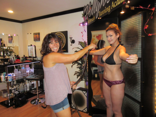 Theresa Torres spray tanning a model'