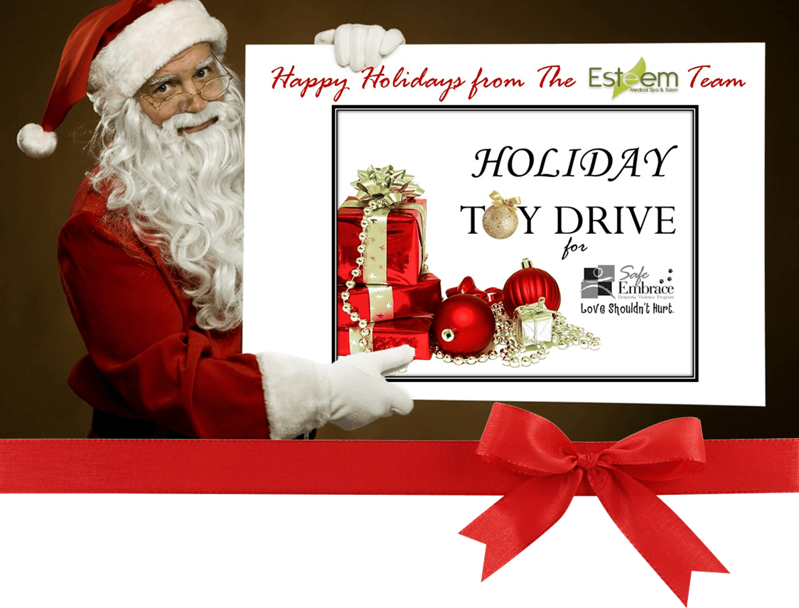 Santa posing with toy drive sign.