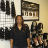 Salon Owner in front of display with Wigs in Atlanta for Can'