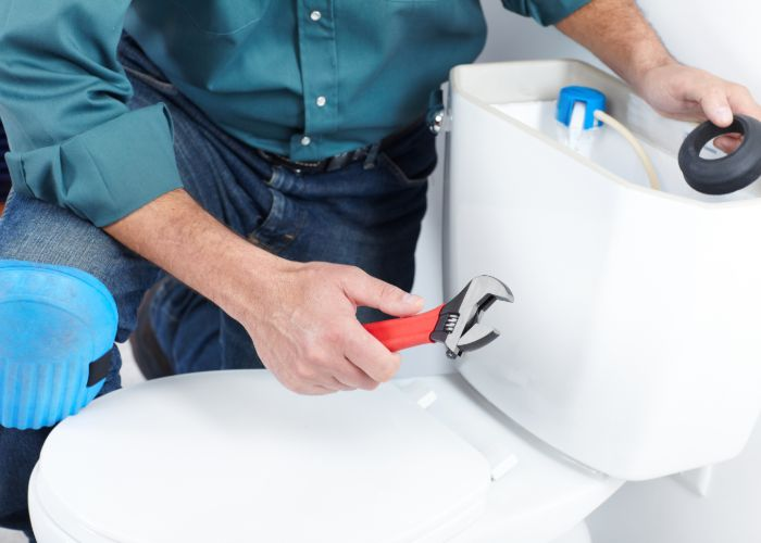 Plumber fixing a toilet leak'