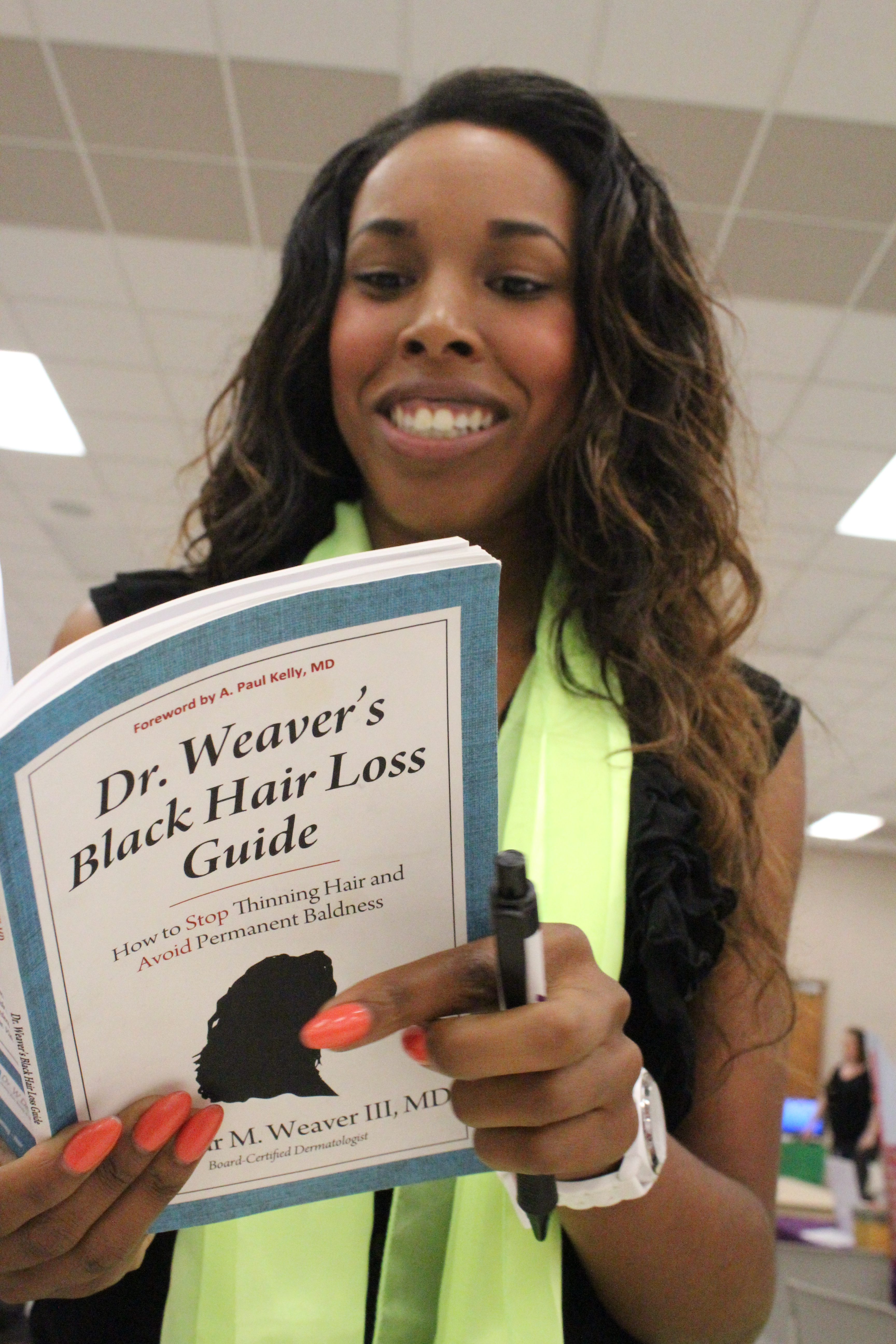 Octavia reading Dr. Seymour Weaver's Black Hair Loss Guide'